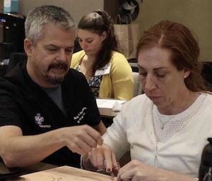 Physician Assistant practicing hands-on suturing skills in small group workshop.